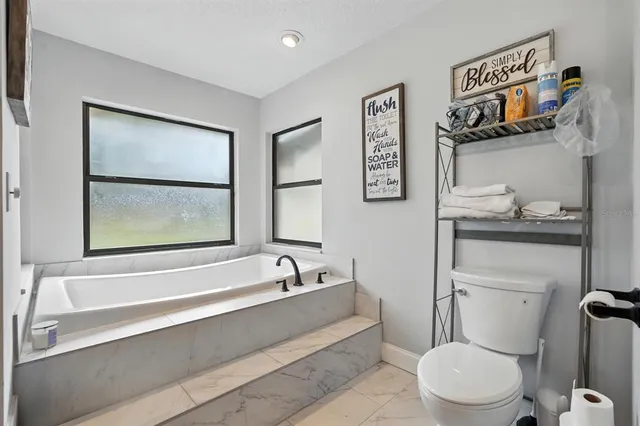 a storage room with lots of clutter fridge and wooden floor