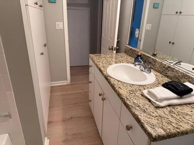 a en suite bathroom with a granite countertop sink and a mirror
