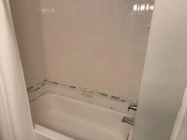 a bedroom with a bed and a flat tv screen on a dresser