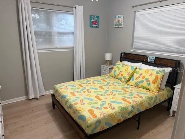 a bedroom with two beds and wooden floor
