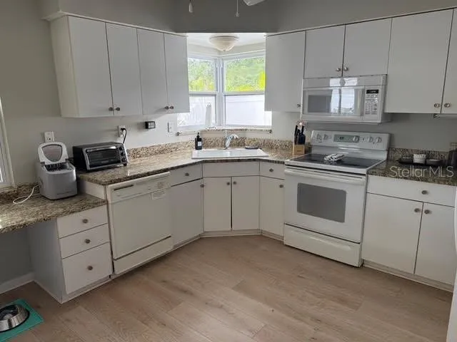 a kitchen with cabinets appliances and a window