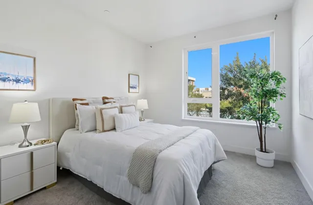 a bedroom with bed and a potted plant
