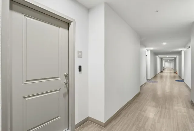 a view of a hallway with wooden floor