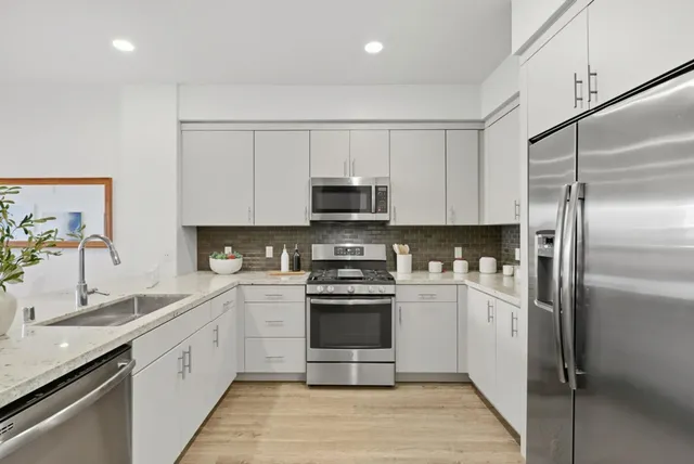 a kitchen with stainless steel appliances granite countertop a refrigerator and a sink