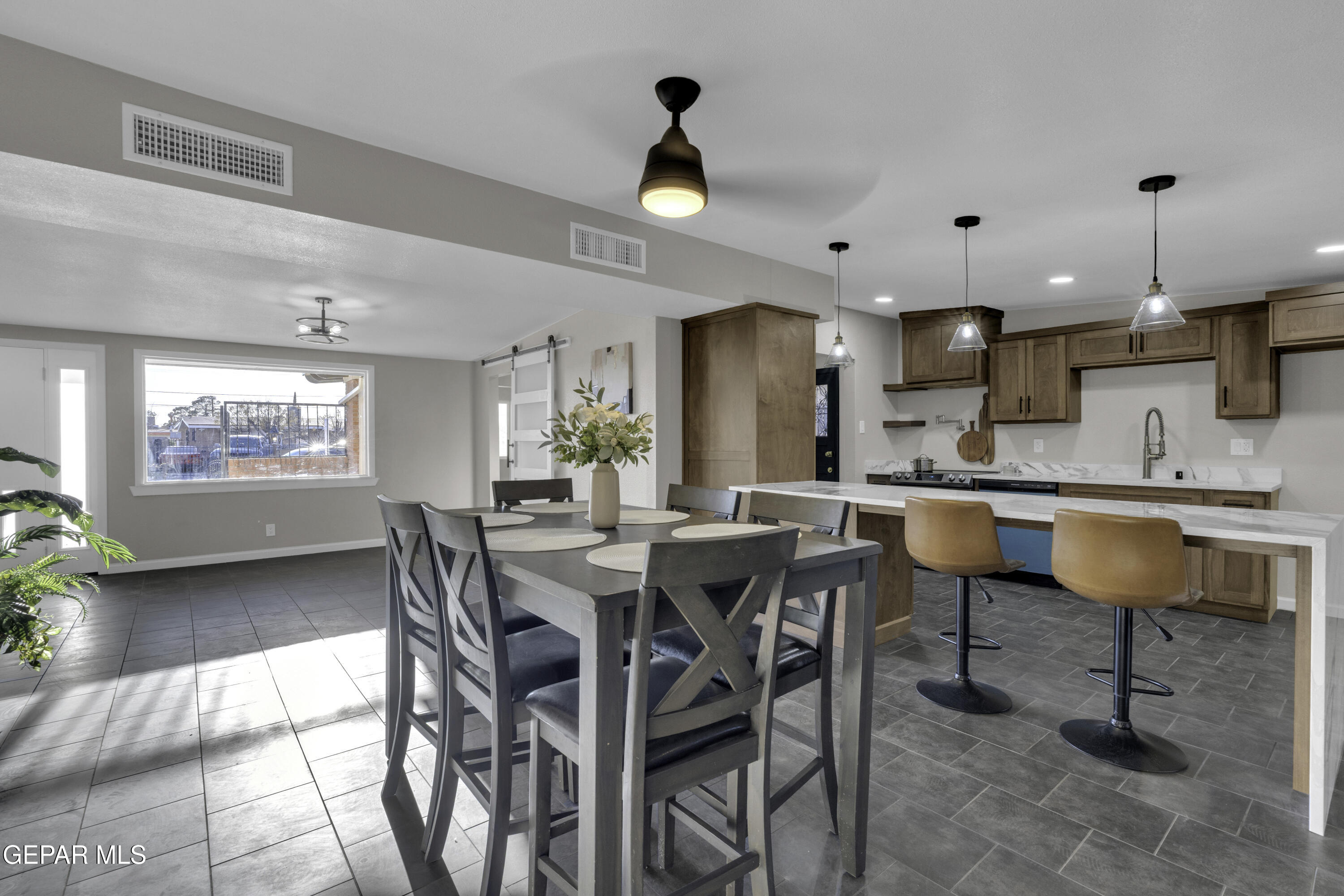 7125 Banana Tree Lane El Paso, TX 79915 - Photo 21 of 62 a kitchen with stainless steel appliances kitchen island granite countertop a dining table chairs and a refrigerator