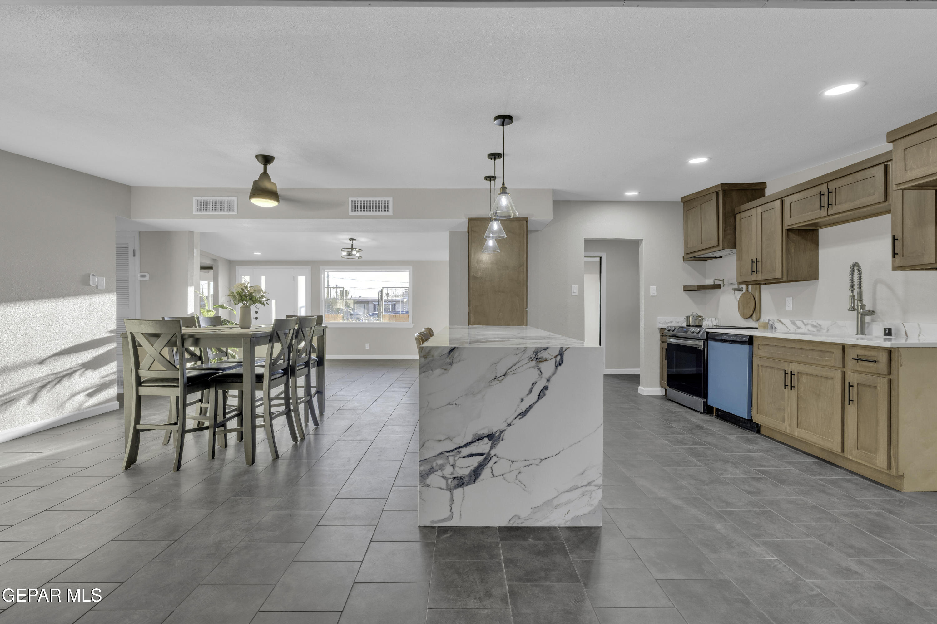 7125 Banana Tree Lane El Paso, TX 79915 - Photo 30 of 62 a dining hall with stainless steel appliances kitchen island granite countertop a table and chairs in it