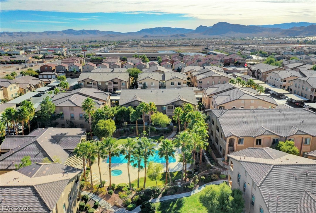 8985 South Durango Drive, Unit 2187 Las Vegas, NV 89113 - Photo 47 of 73 An aerial perspective showcases a vibrant community with a sparkling pool and lush landscaping, nestled against a mountain backdrop.