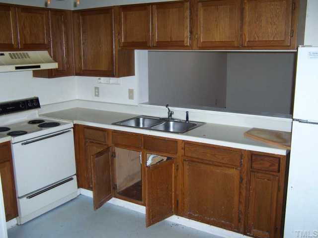 7701 Sandra Lane Raleigh, NC 27615 - Photo 2 of 4 a kitchen with sink cabinets and stove top oven