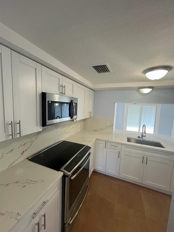 3631 Grayton Drive New Port Richey, FL 34652 - Photo 7 of 42 a kitchen that has a sink and a stove in it