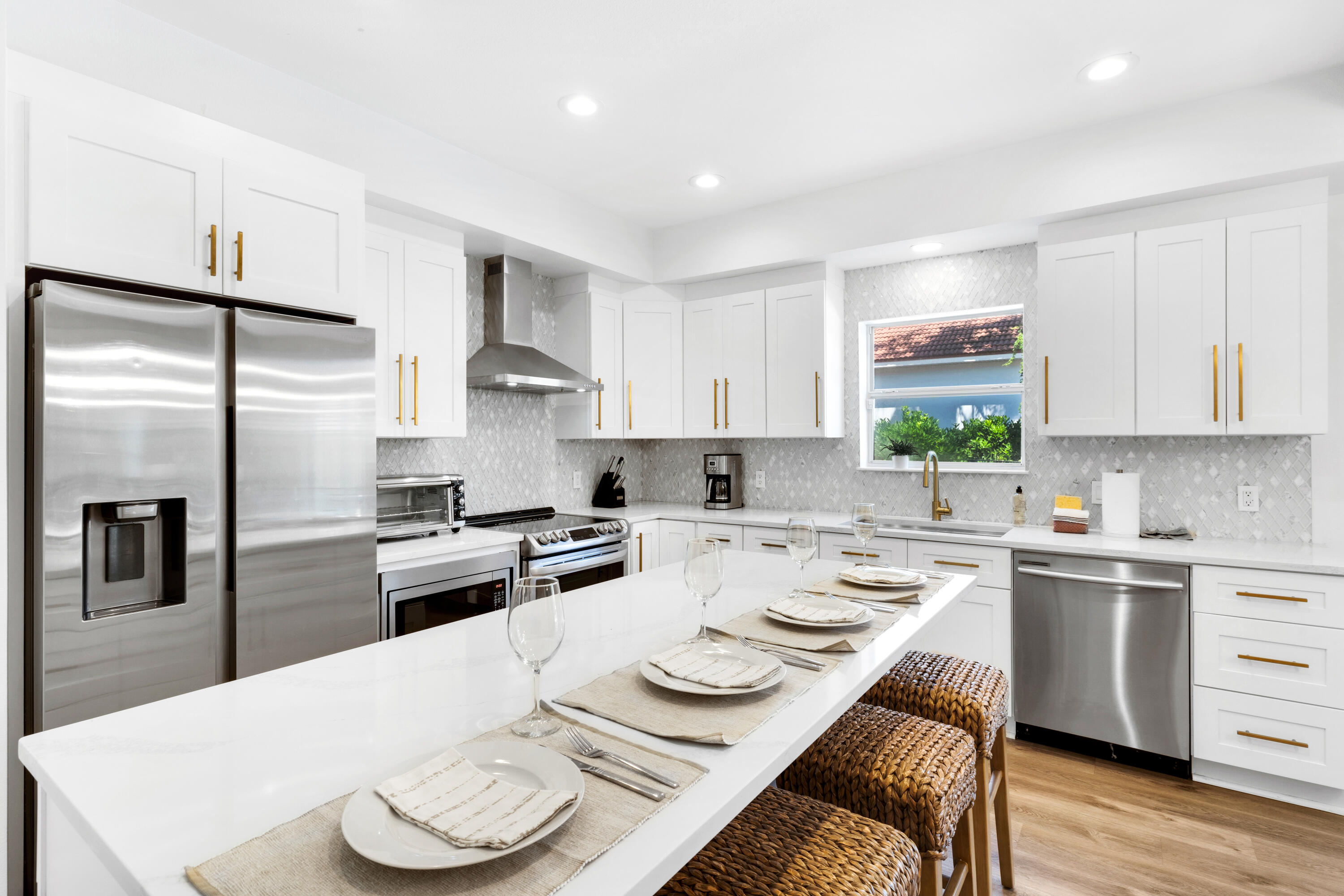 4621 Paradise Isle Destin, FL 32541 - Photo 14 of 65 a kitchen with stainless steel appliances kitchen island granite countertop a sink a stove a refrigerator and white cabinets