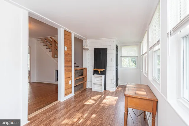 a view of a room with wooden floors and window