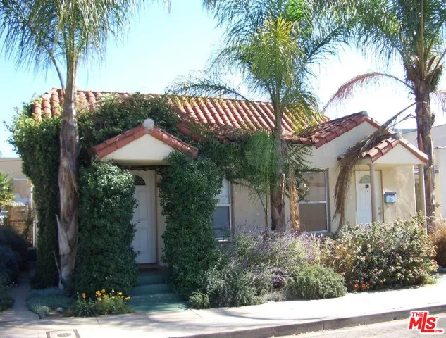 a view of a house with a yard and potted plants