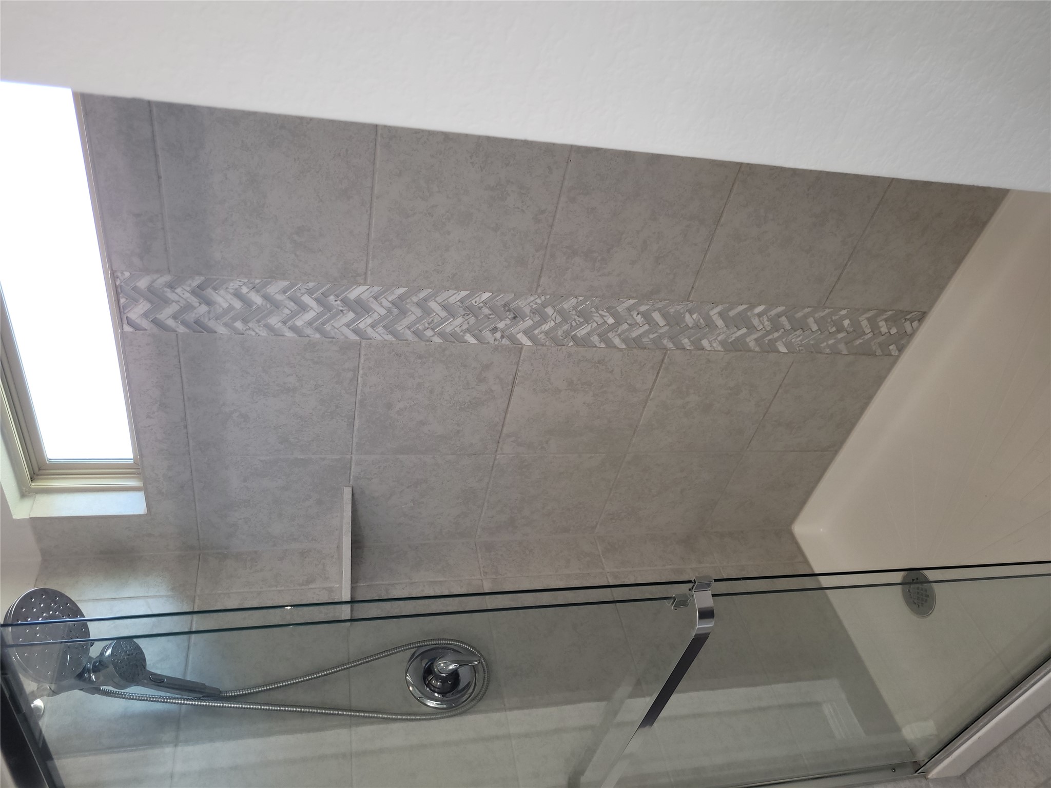 8308 Daisy Cutter Crossing Georgetown, TX 78626 - Photo 18 of 27 A sleek, contemporary shower with a stylish accent tile strip offers a rejuvenating experience.