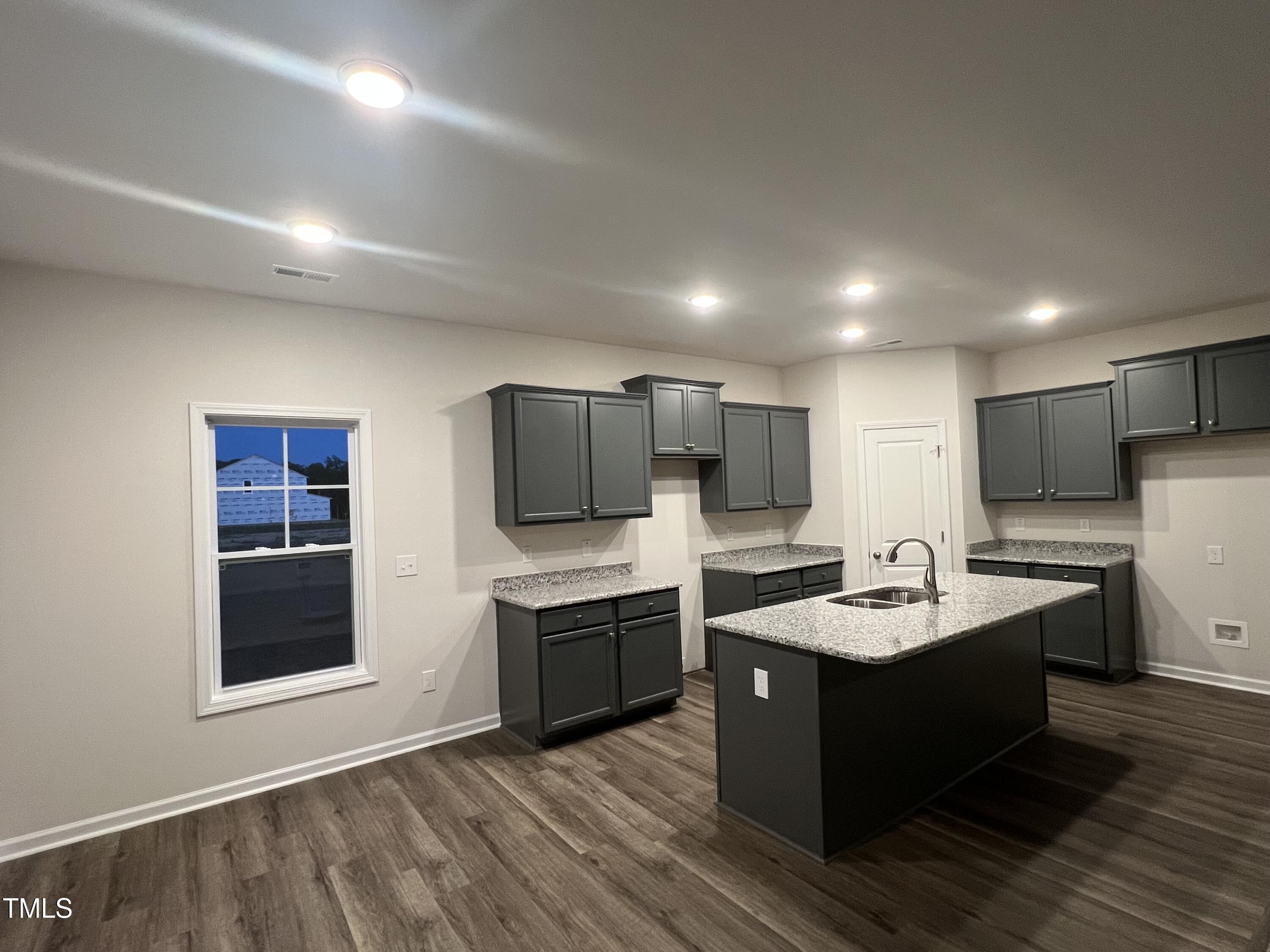 259 Palomo Place Raeford, NC 28376 - Photo 2 of 23 a large kitchen with stainless steel appliances a stove a sink dishwasher a microwave oven and a refrigerator with wooden floor