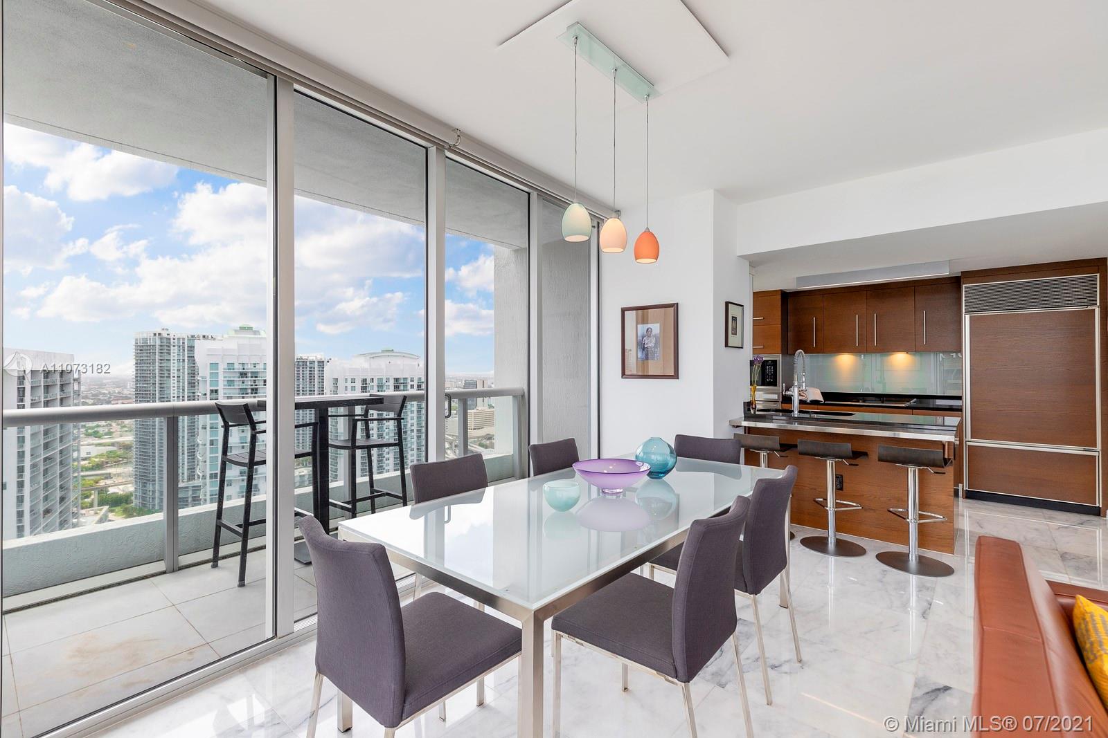 485 Brickell Avenue, Unit 4108 Miami, FL 33131 - Photo 8 of 21 a kitchen with a table chairs and flat screen tv