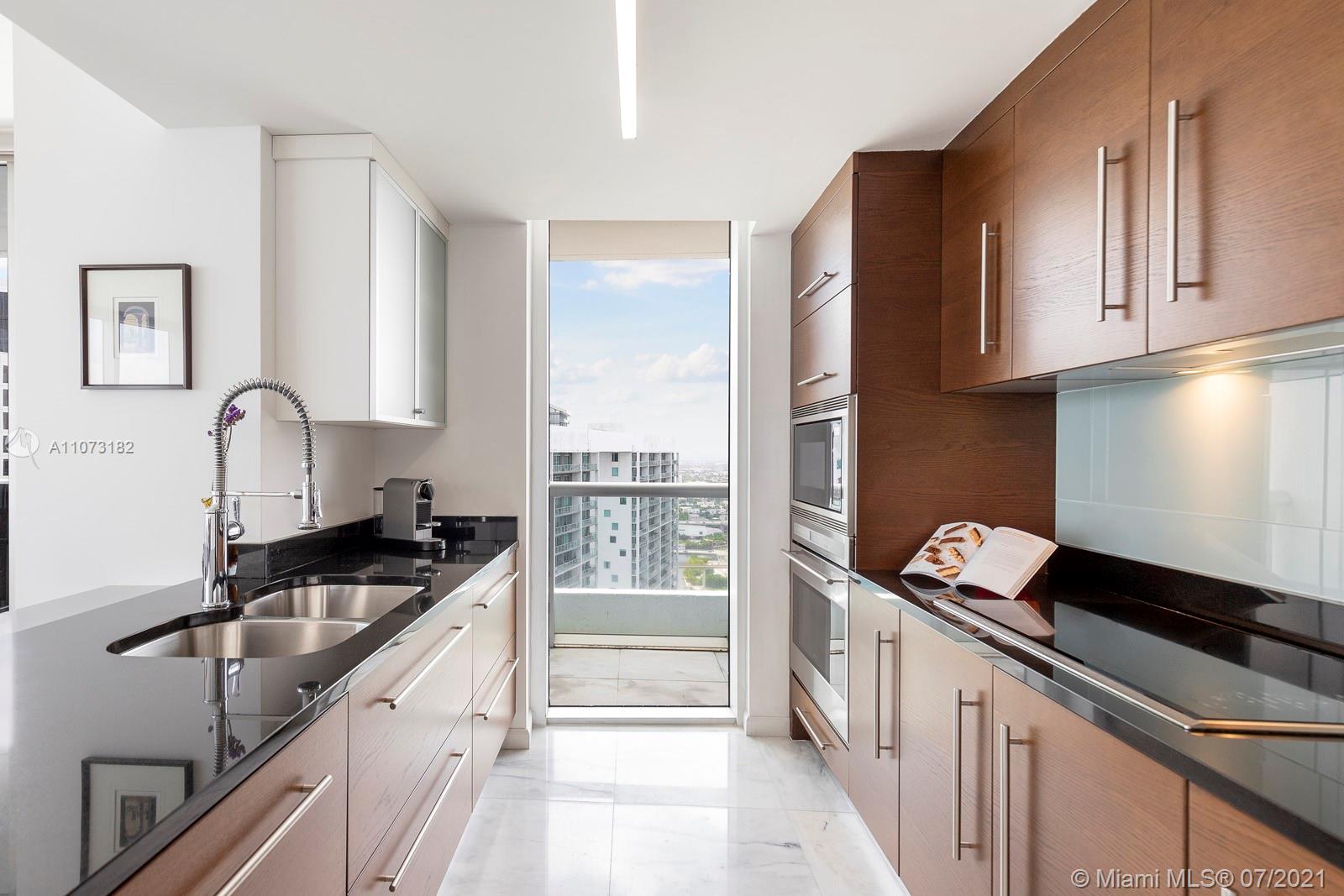 485 Brickell Avenue, Unit 4108 Miami, FL 33131 - Photo 10 of 21 a kitchen with granite countertop a sink and cabinets