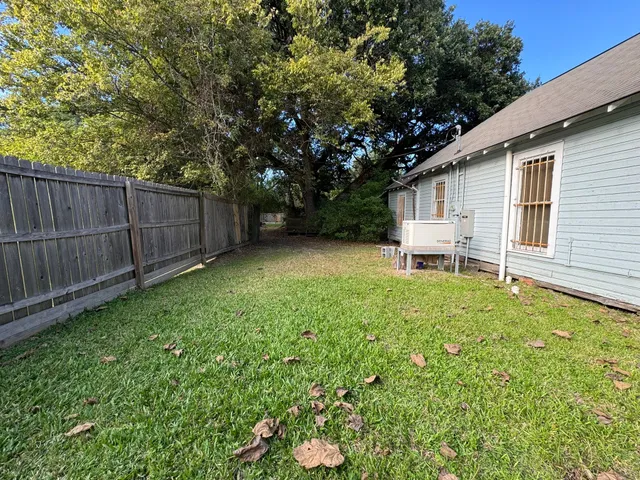 a backyard of a house with wooden floor and fence