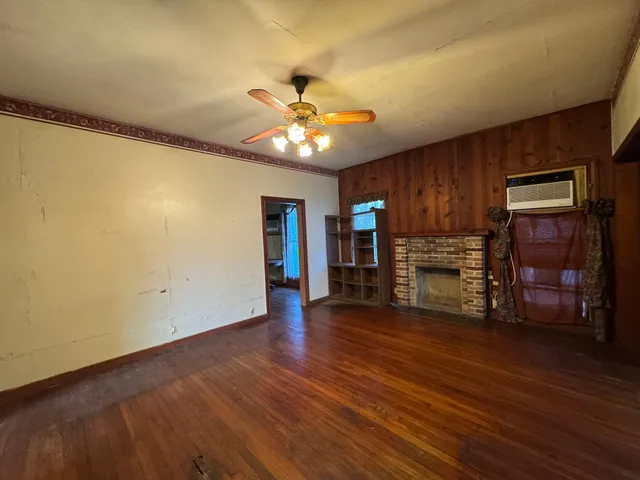 a view of empty room with wooden floor and ceiling fan