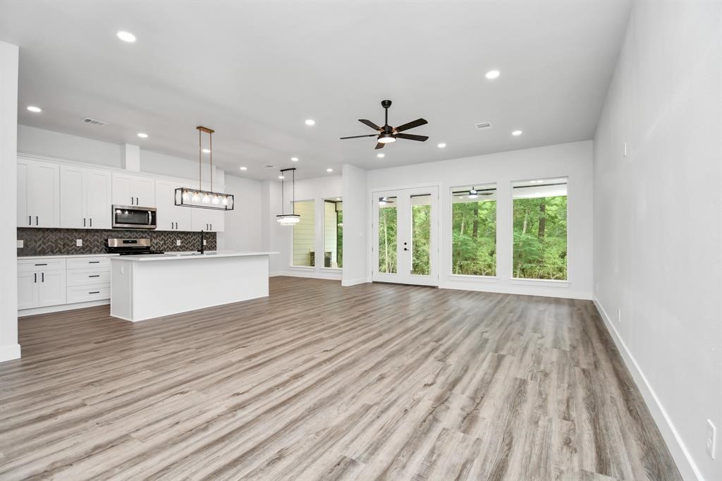 12163 La Salle River Road Conroe, TX 77304 - Photo 12 of 27 a view of an empty room with a window and wooden floor