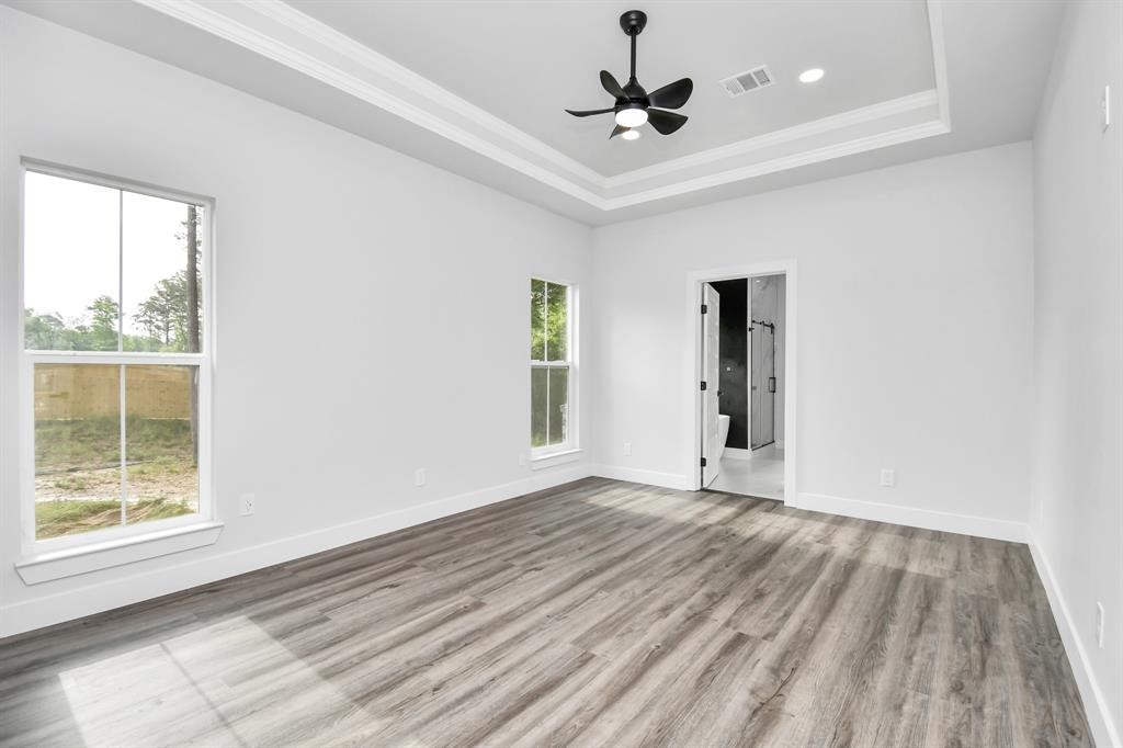 12163 La Salle River Road Conroe, TX 77304 - Photo 17 of 27 a view of an empty room with a window and wooden floor