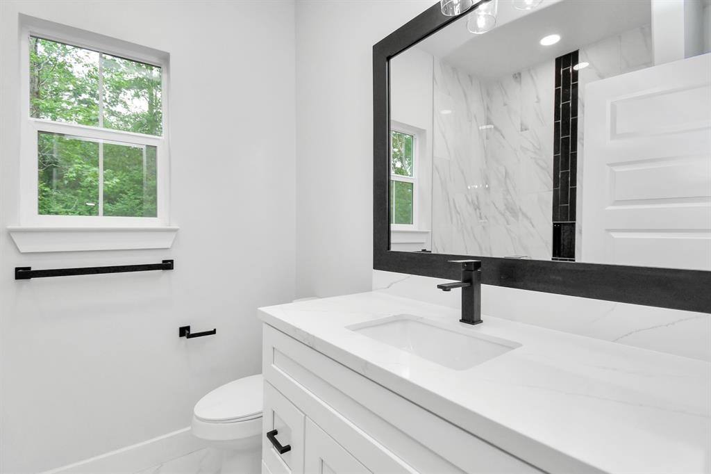 12163 La Salle River Road Conroe, TX 77304 - Photo 8 of 27 a bathroom with a sink toilet and mirror