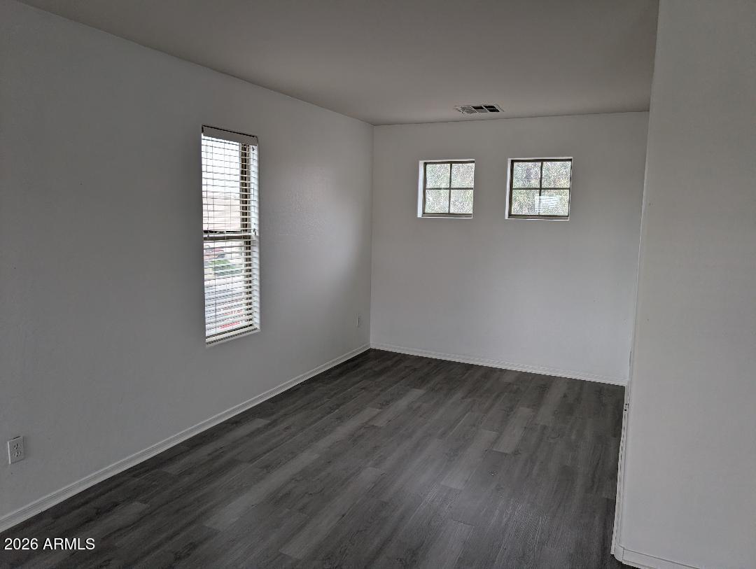 17537 West Banff Lane Surprise, AZ 85388 - Photo 6 of 11 a view of an empty room with wooden floor and a window