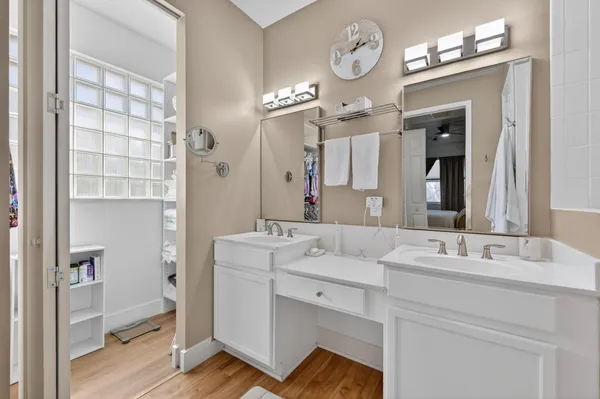 a spacious bathroom with a double vanity sink a mirror and a toilet