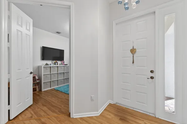 a living room with furniture kitchen view and a wooden floor