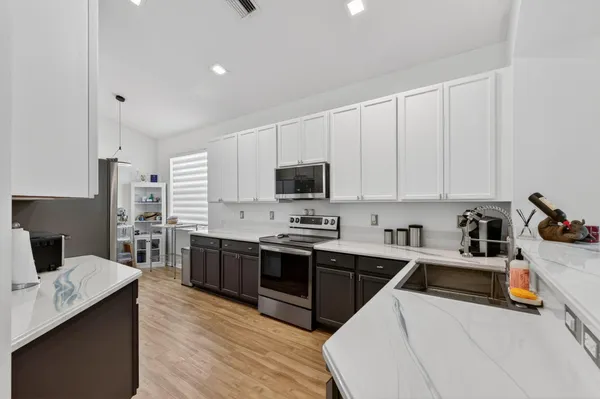 a kitchen with a refrigerator a sink dishwasher and a stove with wooden floor