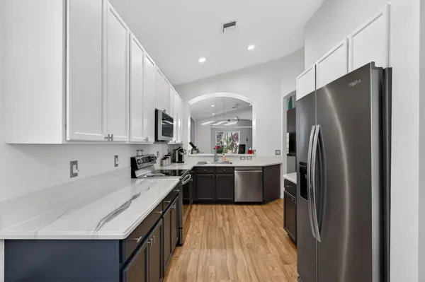 a kitchen with stainless steel appliances granite countertop a sink stove and refrigerator