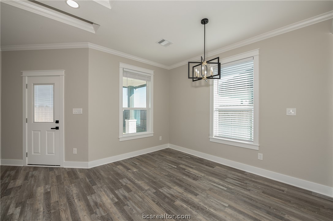 2908 GOLDBERG Drive Bryan, TX 77808 - Photo 25 of 44 View of the dining area and rear porch, decorative chandelier light, window treatments, pop up ceilings and vinyl flooring.