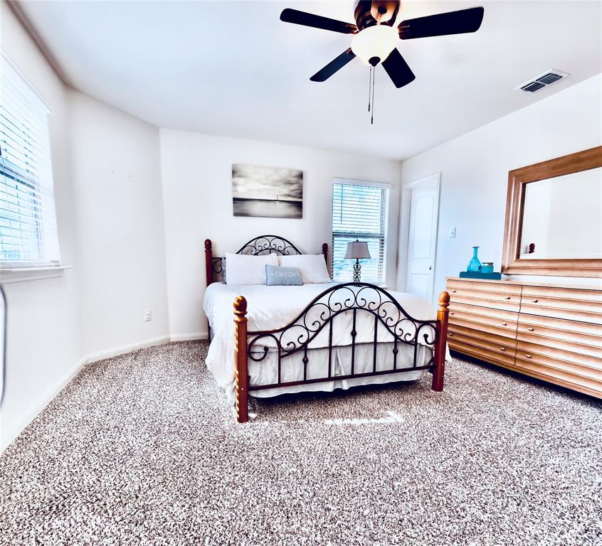 196 Cattlemans Crk Road West Newark, TX 76071 - Photo 18 of 31 Bedroom featuring ample natural light from multiple windows, textured carpet flooring, a ceiling fan with integrated lighting, and crisp white walls