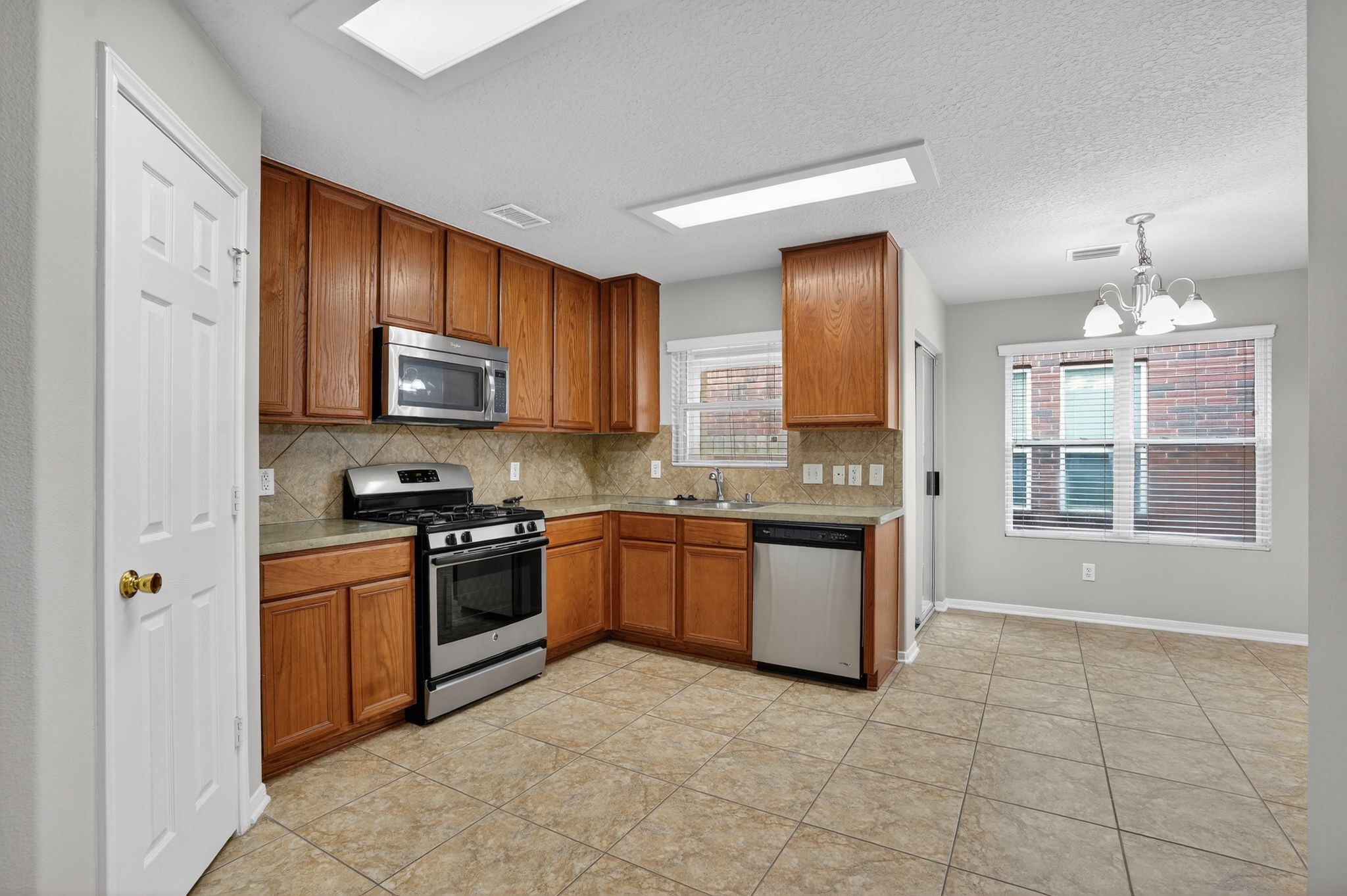 29414 Winton Wood Way Spring, TX 77386 - Photo 8 of 35 a kitchen with stainless steel appliances granite countertop a stove top oven a sink a counter space and cabinets