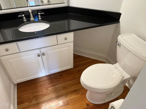 a bathroom with a sink mirror vanity and toilet