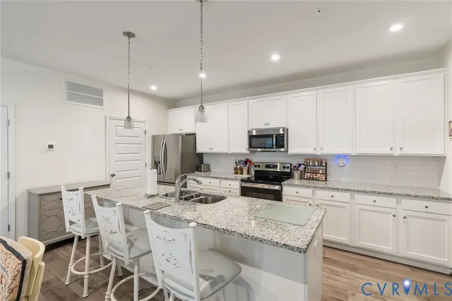 a kitchen with stainless steel appliances kitchen island granite countertop a sink and cabinets