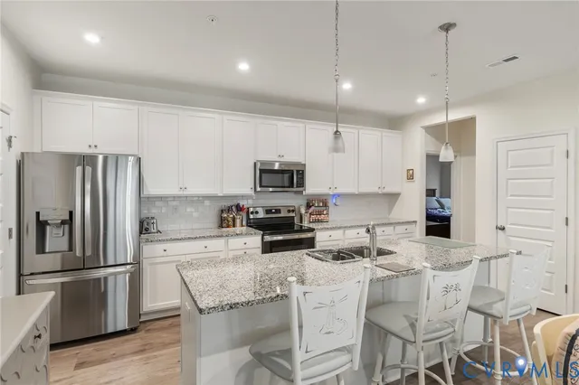 a kitchen with granite countertop a refrigerator stove microwave and cabinets