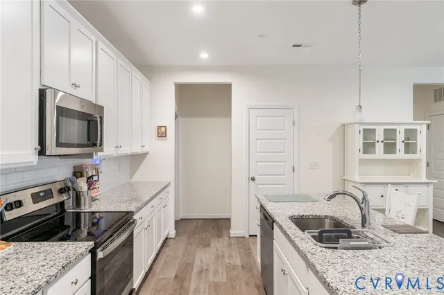 a kitchen with a sink stove top oven and refrigerator