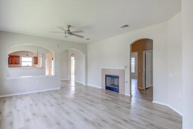 an empty room with windows and fireplace