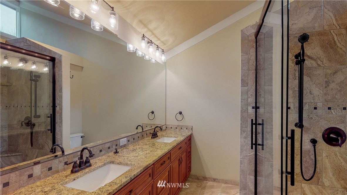 7425 Bordeaux Road Southwest Olympia, WA 98512 - Photo 14 of 25 a bathroom with a granite countertop sink a mirror and shower