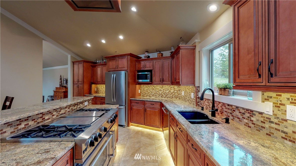 7425 Bordeaux Road Southwest Olympia, WA 98512 - Photo 7 of 25 a kitchen with stainless steel appliances granite countertop sink stove and refrigerator
