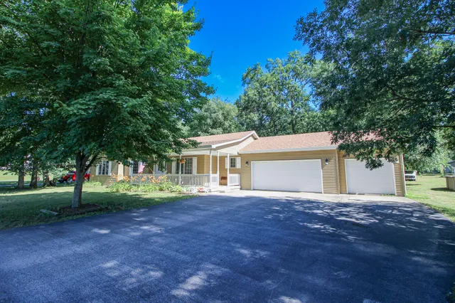 a front view of a house with a tree and a yard