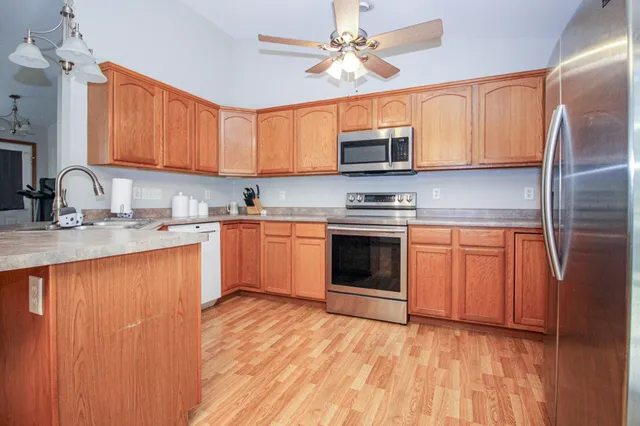 a kitchen with stainless steel appliances granite countertop a stove a sink dishwasher and a refrigerator