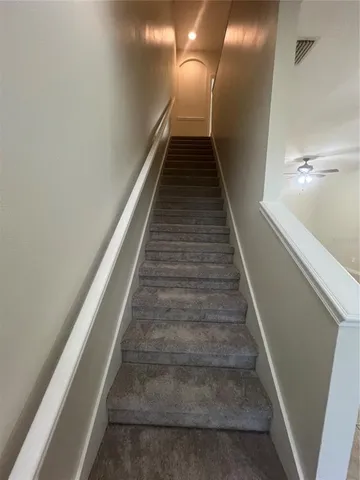 a view of hallway with stairs and a wooden floor