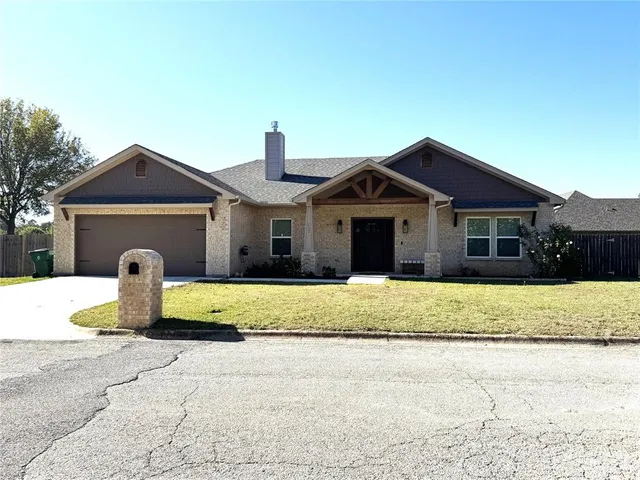 a front view of a house with a garden and yard