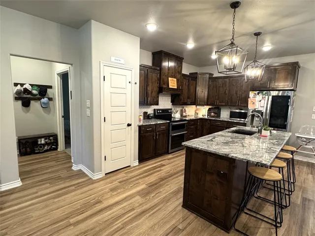 a kitchen with kitchen island granite countertop wooden cabinets and a refrigerator