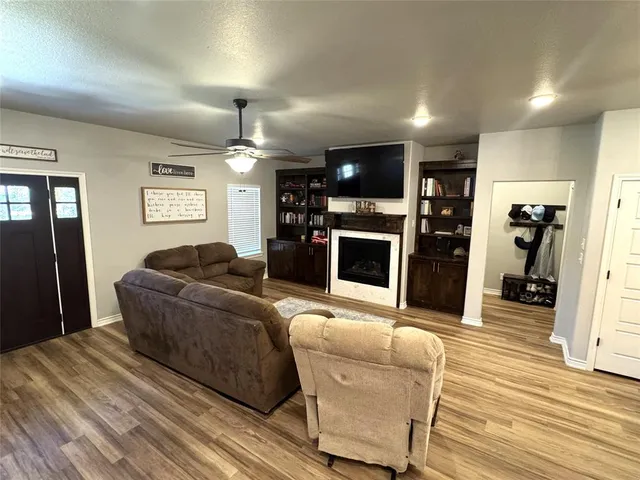 a living room with furniture a flat screen tv and a fireplace