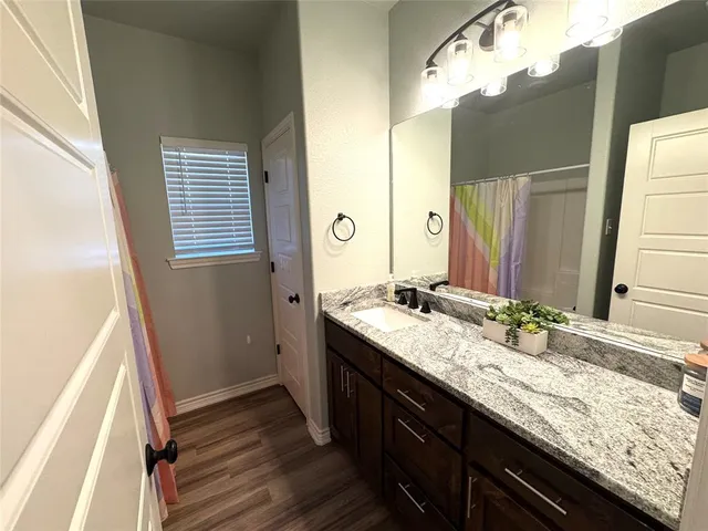 a bathroom with a granite countertop double vanity sink and mirror