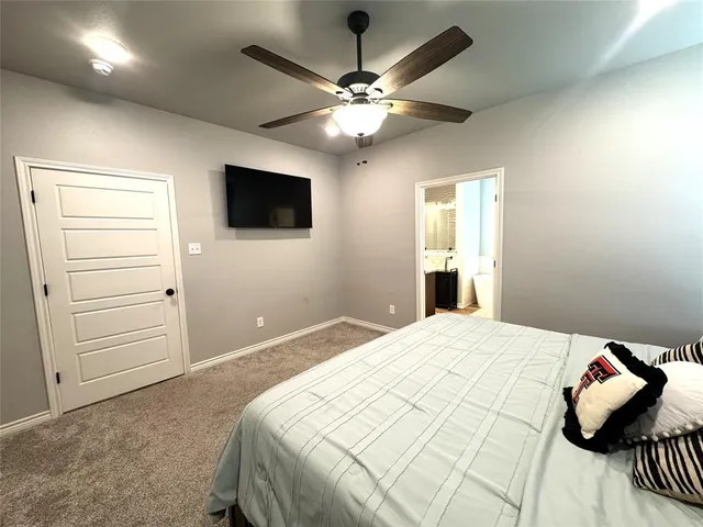 a bedroom with a large bed and a flat screen tv