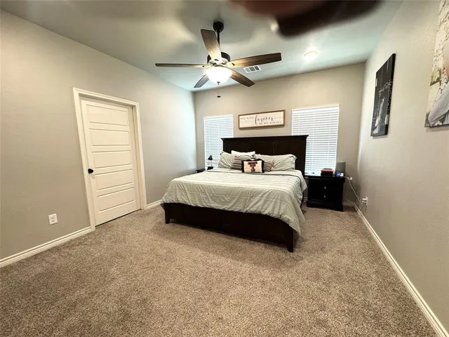 a bedroom with a large bed and ceiling fan