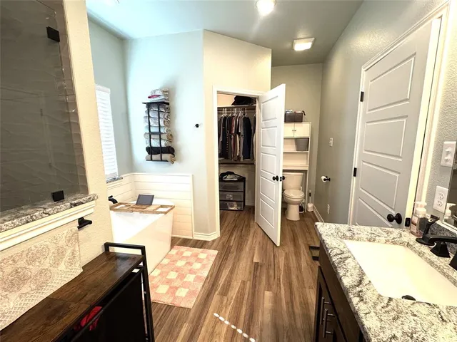 a spacious bathroom with a tub sink and mirror